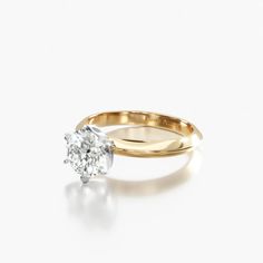 a yellow gold engagement ring with a single diamond in the center, on a white background