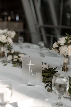 the table is set with white flowers and place cards