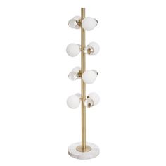 a gold and white floor lamp with five globes on the base, all in different sizes