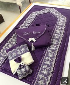 an item is displayed on the table with purple and white fabric, which has been embroidered onto it