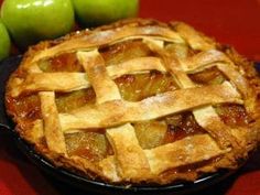 an apple pie sitting on top of a red table