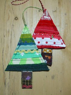 two christmas tree ornaments hanging on a wooden wall