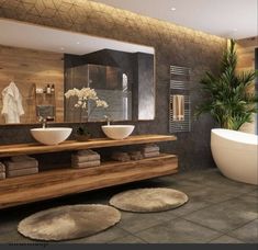 a bathroom with two sinks and a bathtub in the middle, surrounded by rugs