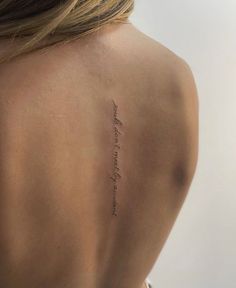 the back of a woman's neck with an inscription on her left side and writing in cursive font