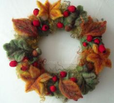 a wool wreath with red berries and green leaves