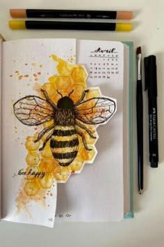 an open notebook with a drawing of a bee on it