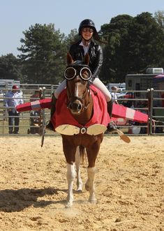 a woman riding on the back of a brown horse