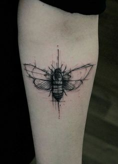 a black and white photo of a bee tattoo on the right side of the leg