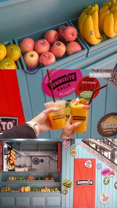 two people holding up drinks in front of some fruit