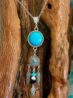 This is unique and one of a kind.Turquoise colored stone wrapped in rope like edging below sits a smaller turquoise colored stone with filigree. 2 tibetan silver feathers dangling on either side of middle dangle With small stones and tiny silver dreamcatcher The bail for holding the chain is antique Tibetan silver and generous in size if larger chain should be desired. Handmade Turquoise Hippie Jewelry, Blue Bohemian Wire Wrapped Jewelry, Bohemian Blue Wire Wrapped Jewelry, Hippie Turquoise Festival Jewelry, Nickel-free Blue Bohemian Necklaces, Blue Bohemian Nickel-free Necklaces, Bohemian Turquoise Necklace With Natural Stones, Adjustable Bohemian Necklaces With Feathers, Bohemian Sterling Silver Dangle Necklaces