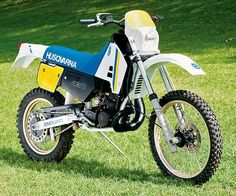 a dirt bike parked on top of a lush green field