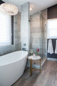 a white bath tub sitting next to a walk in shower