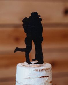 a wedding cake with a silhouette of two people on top