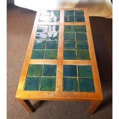 a coffee table with green tiles on it in the middle of a carpeted room