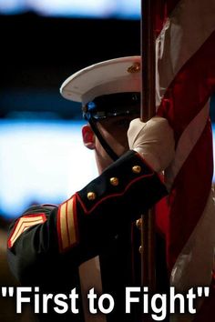 a man in uniform saluting the american flag with his hand on top of an american flag