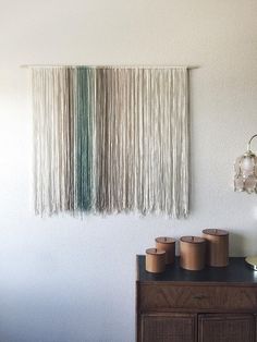 the wall hanging is made from yarn and wood