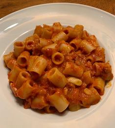 a white plate topped with pasta covered in sauce