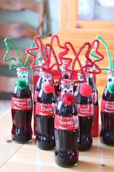 six bottles with red and green decorations in them sitting on a table next to each other