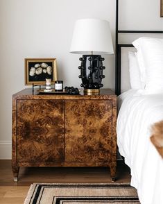 a bed room with a neatly made bed and a night stand next to the bed