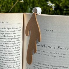 an open book with a wooden cutout of a person