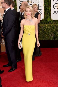 a woman in a yellow dress on the red carpet