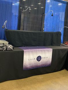 a table with some luggage on it in front of blue curtained walls and windows