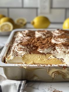 a cake in a pan with lemons behind it