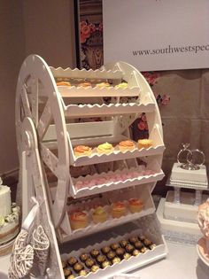 a table topped with lots of cakes and cupcakes