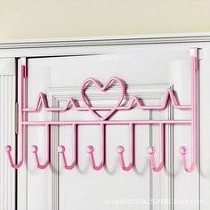 a pink heart and heartbeat hook on a white door with the word love spelled in it