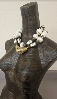 This bold, chunky and heavy white magnesite, inlaid Tibetan conch, wood rondelle, zebu bone, rhinestone rondelle and African lost wax brass necklace is the perfect accessory to pair with your wild and exotic animal print cuffs and rings for summer wear. An African lost wax brass "elbow bead" is the focal point in the very front. This is a dense piece with weight so please know your tolerance before you buy. Adjusts from 17-20" and I can add more links if requested. Closes with a gold tone hook a Artisan White Necklace, White Bohemian Jewelry With Wooden Beads, Bohemian White Jewelry With Wooden Beads, White Artisan Necklace With Wooden Beads, Artisan White Beaded Necklaces With Large Beads, Artisan White Necklace With Wooden Beads, Artisan White Beaded Necklace With Large Beads, Unique White Jewelry For Festivals, Unique White Festival Jewelry