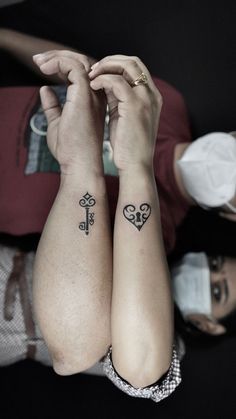 two people with matching tattoos on their arms