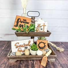 two tiered trays with wooden signs and succulents in them on top of each other