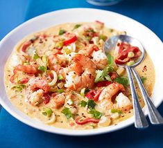 a bowl of soup with shrimp and tomatoes