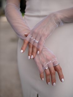 a woman wearing white gloves and holding her hands with the word love written on it