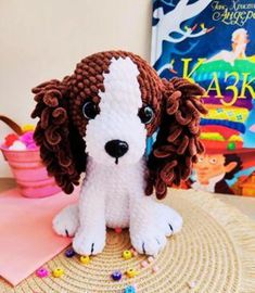 a stuffed dog sitting on top of a straw hat next to a book and toy