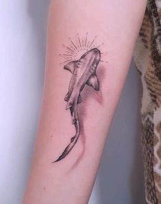 a shark tattoo on the left arm