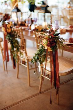 a long table with chairs and flowers on it