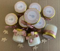 several small jars with bows on them are sitting next to some tiny cookies and confetti