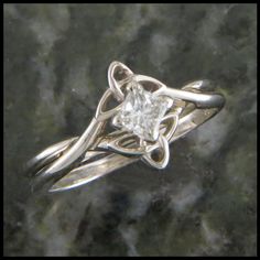 a white gold ring with a princess cut diamond