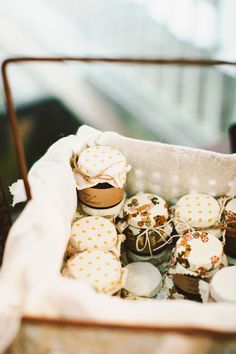 a basket filled with lots of cupcakes on top of a table