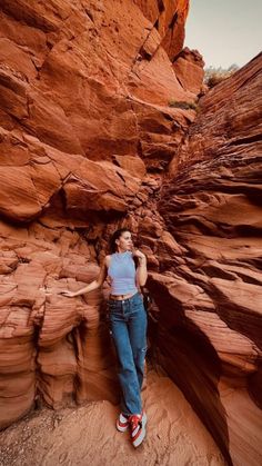 a woman standing in the middle of a canyon