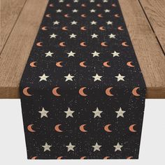 a black table runner with stars and crescents on it, sitting on top of a wooden