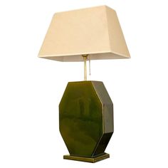 a green table lamp with a white shade on it