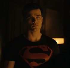 a man with a superman t - shirt in the dark