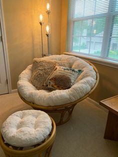 a dog bed in the corner of a room with two stools and a table