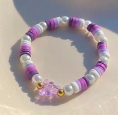 a purple and white beaded bracelet sitting on top of a table