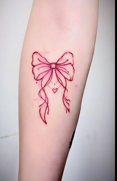 a woman's arm with a red bow tattoo on the left side of her body