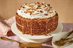 a cake sitting on top of a white plate next to a fork and spoons