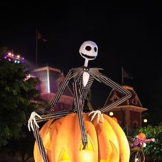 a skeleton sitting on top of a giant pumpkin