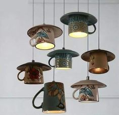 coffee mugs hanging from the ceiling in a room with white walls and flooring